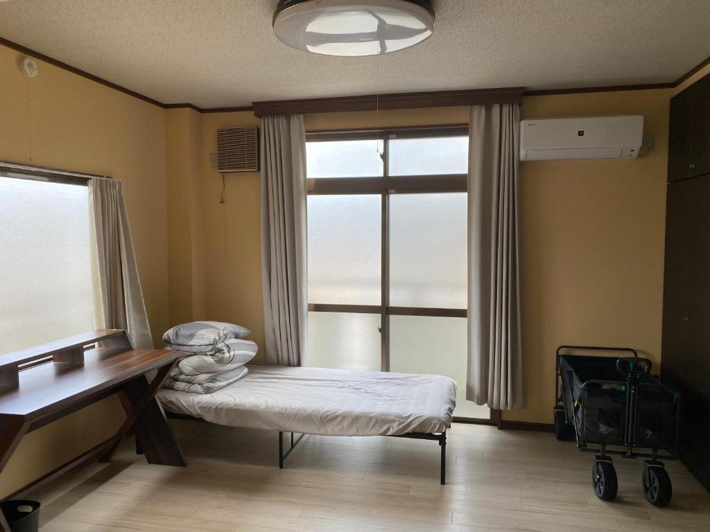 een ziekenhuiskamer met een bed en een raam bij 快適に滞在&家族利用等におすすめ 洋室と和室が繋がったお部屋 in Gifu