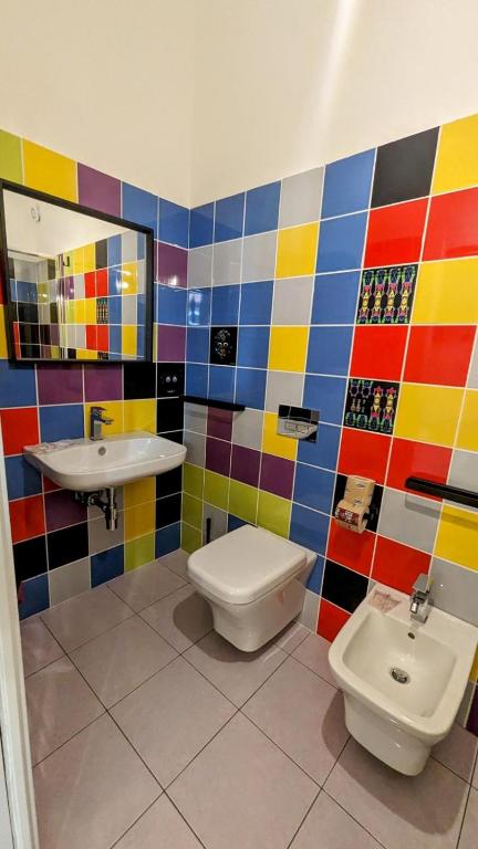 bagno colorato con servizi igienici e lavandino di Accomodation Libertino a Tropea