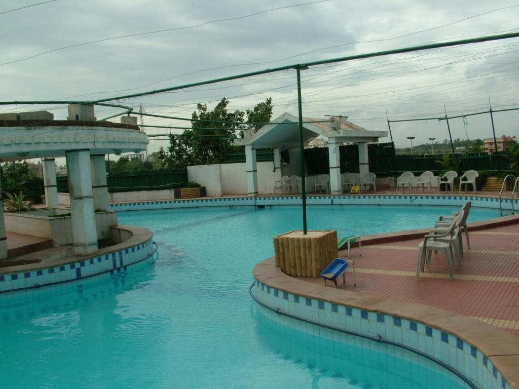 een zwembad met blauw water in een resort bij VIP'S CLUB in Raipur