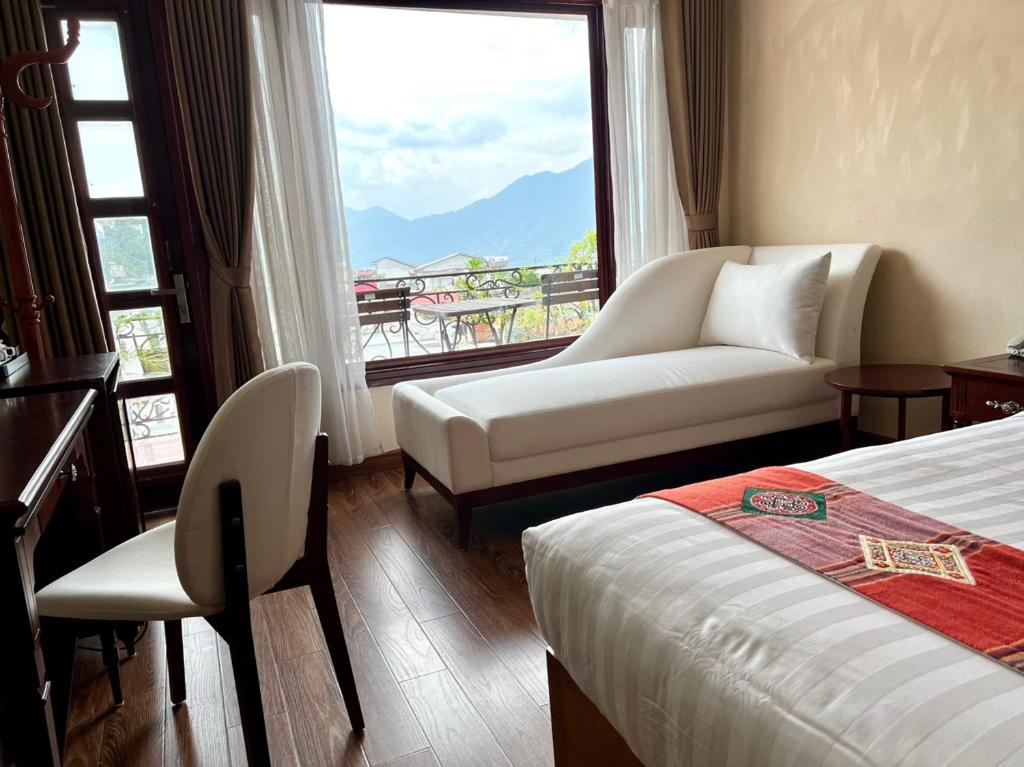 a hotel room with a bed and a couch and a window at Sapa Centre Hotel in Sapa