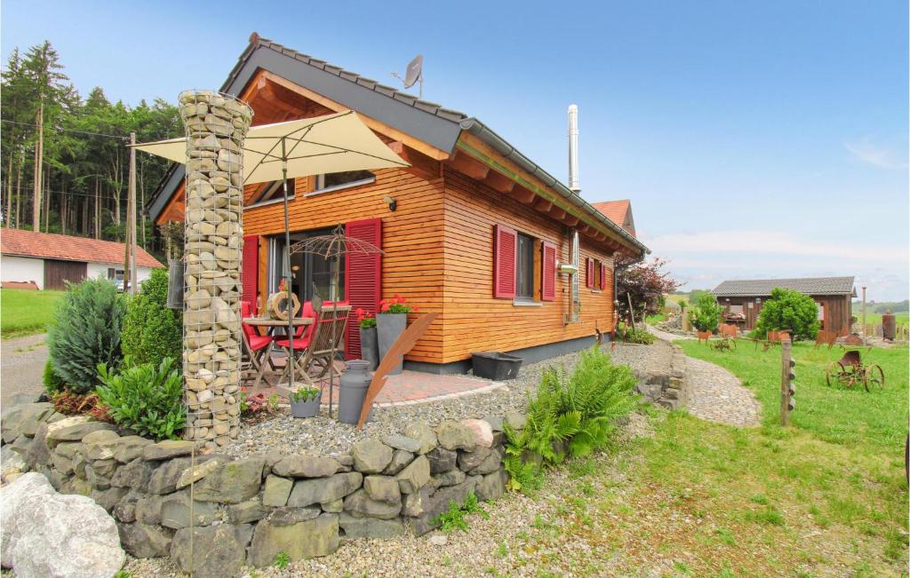 a small wooden house with a stone wall at Schoorenmoos Lodge in Dietmannsried