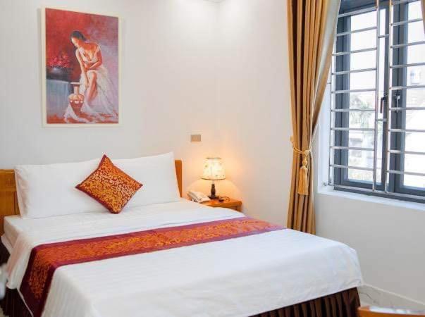 Happy Hotel في Uông Bí: غرفة نوم بسرير ابيض ونافذة