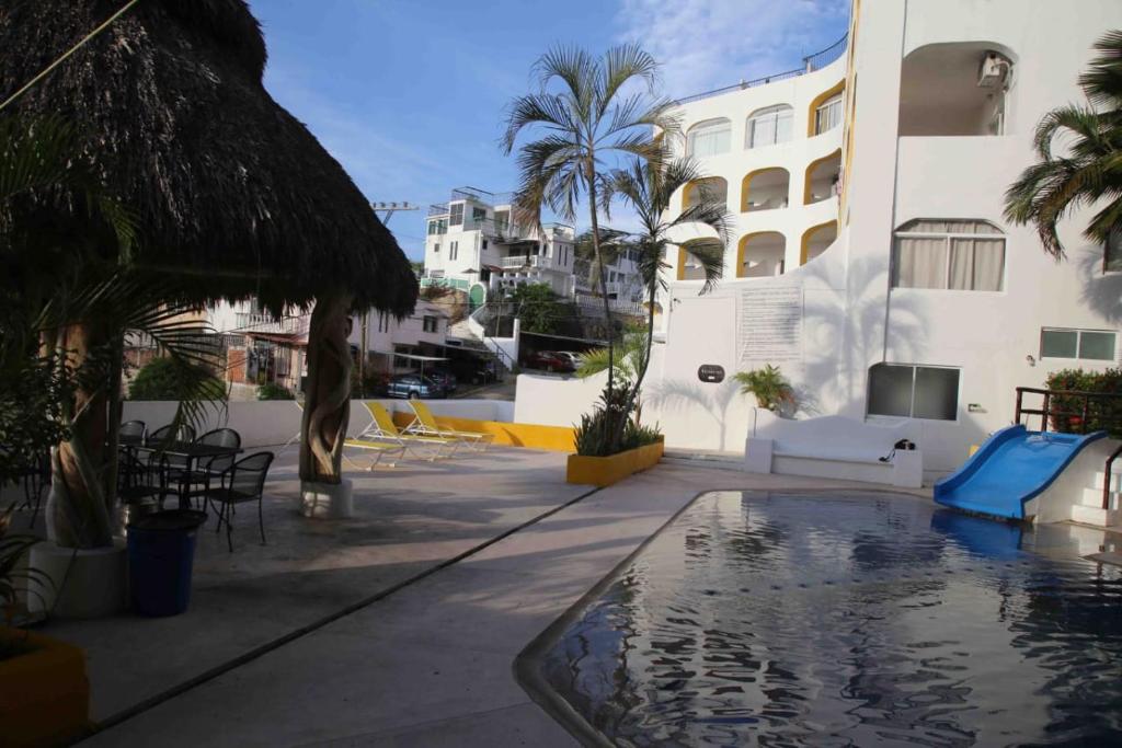 a swimming pool in the middle of a building with palm trees at Departamento Acapulco tres mares in Acapulco