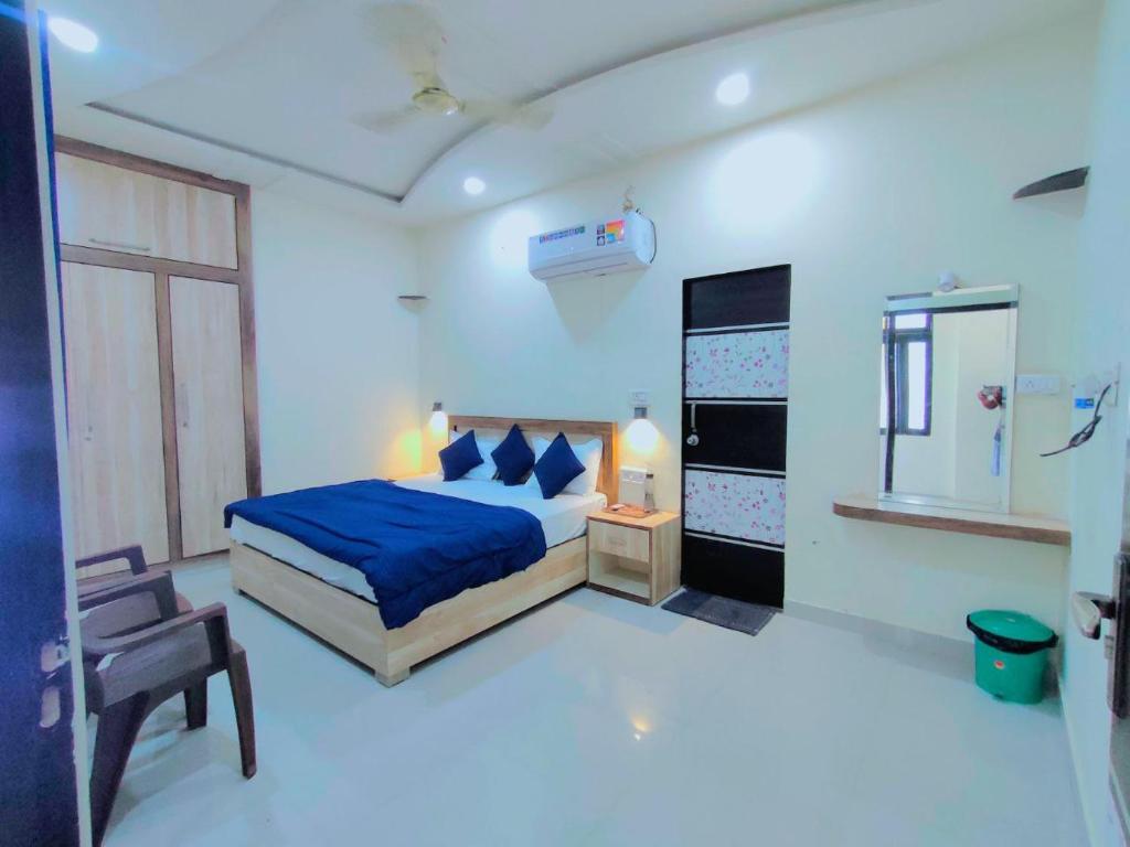 una camera con un letto blu e una sedia di Hill Top Residency a Sawai Madhopur