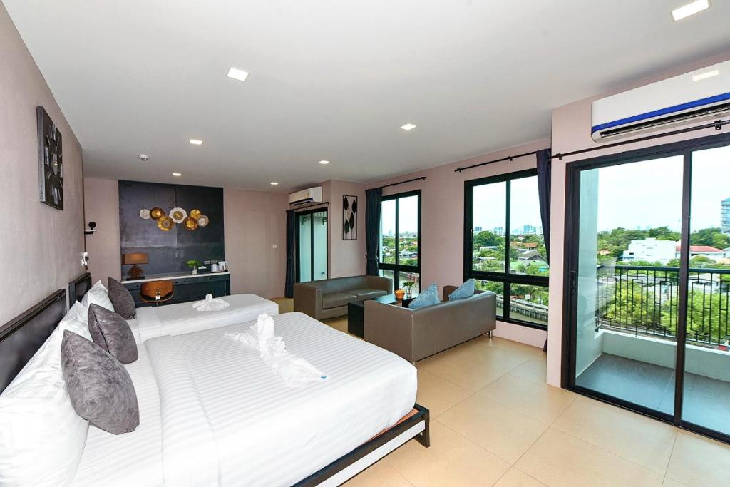 - une chambre avec un lit blanc et un salon dans l'établissement NORN Rimkhlong Bangkok นอนริมคลอง, à Bangkok Noi
