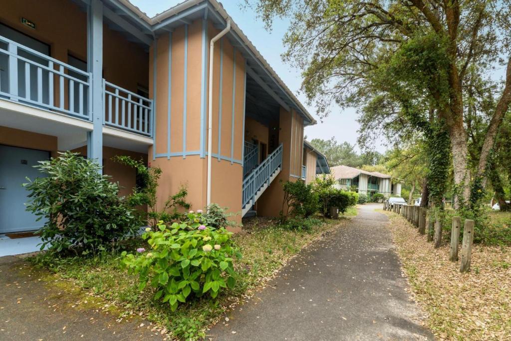 une vue latérale sur un bâtiment avec des arbres et des plantes dans l'établissement Le Domaine du Golf de Pinsolle - maeva Home - Appartement 2 pièces 5 personnes - Confort MAE-7244, à Soustons
