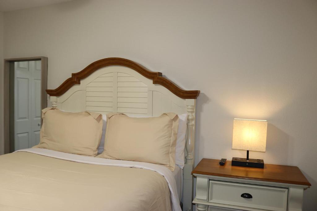 a bedroom with a bed and a lamp on a night stand at Hidden Ruby-Apartment with Kitchen and Laundry in Lakeland