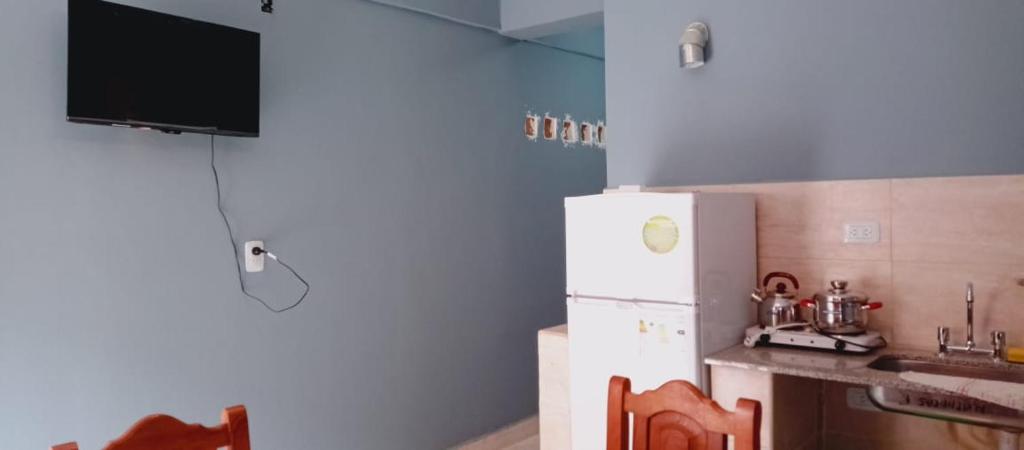 een keuken met een witte koelkast en een wastafel bij Apartamentos El quincho in El Carmen