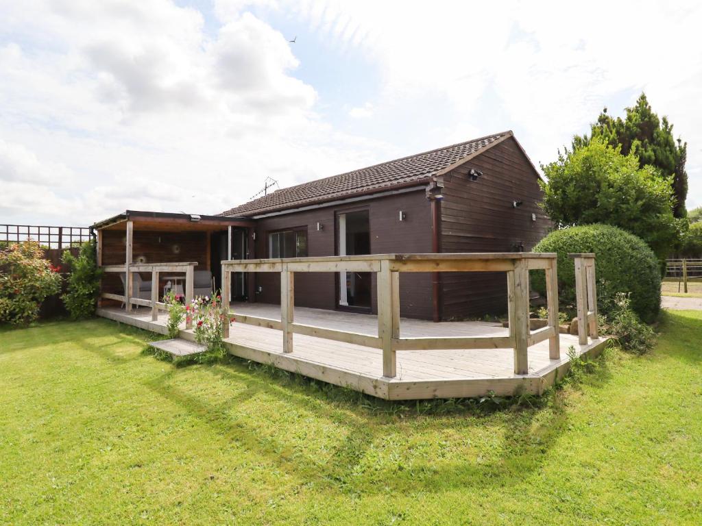 a house with a large deck in the yard at Meols Holiday Lodge in Wirral