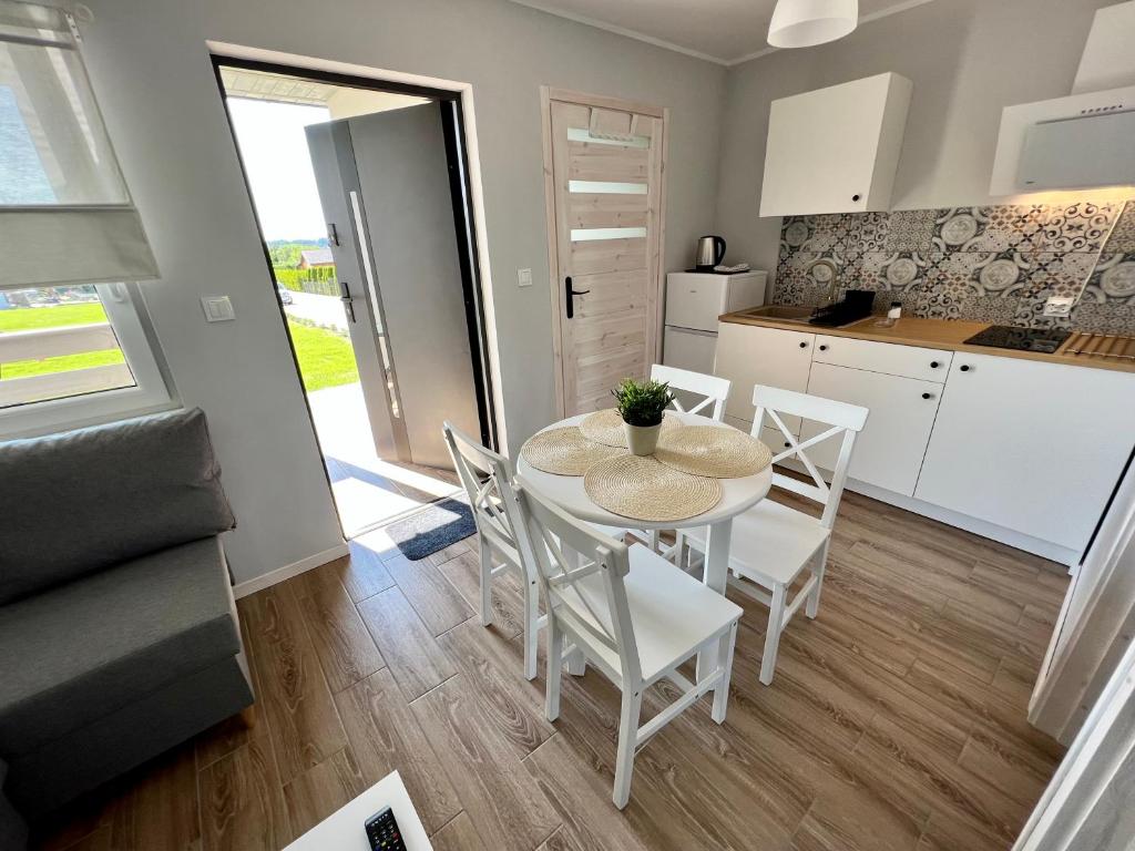 a kitchen and dining room with a table and chairs at Domki Maju Maj in Darłowo