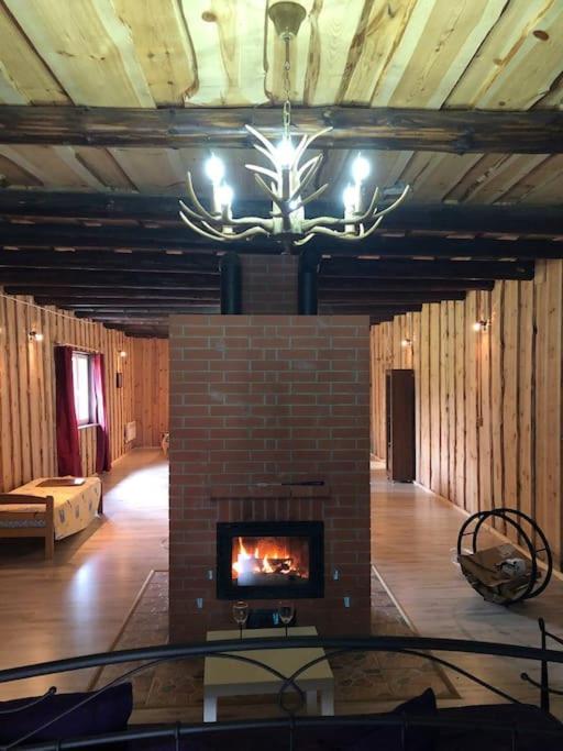 d'un salon avec une cheminée et un lustre. dans l'établissement The Barn, à Pärnu