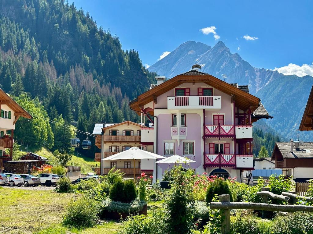 a large pink building in front of a mountain at B&B Cèsa Planber Mountain View BIKE FRIENDLY in Canazei