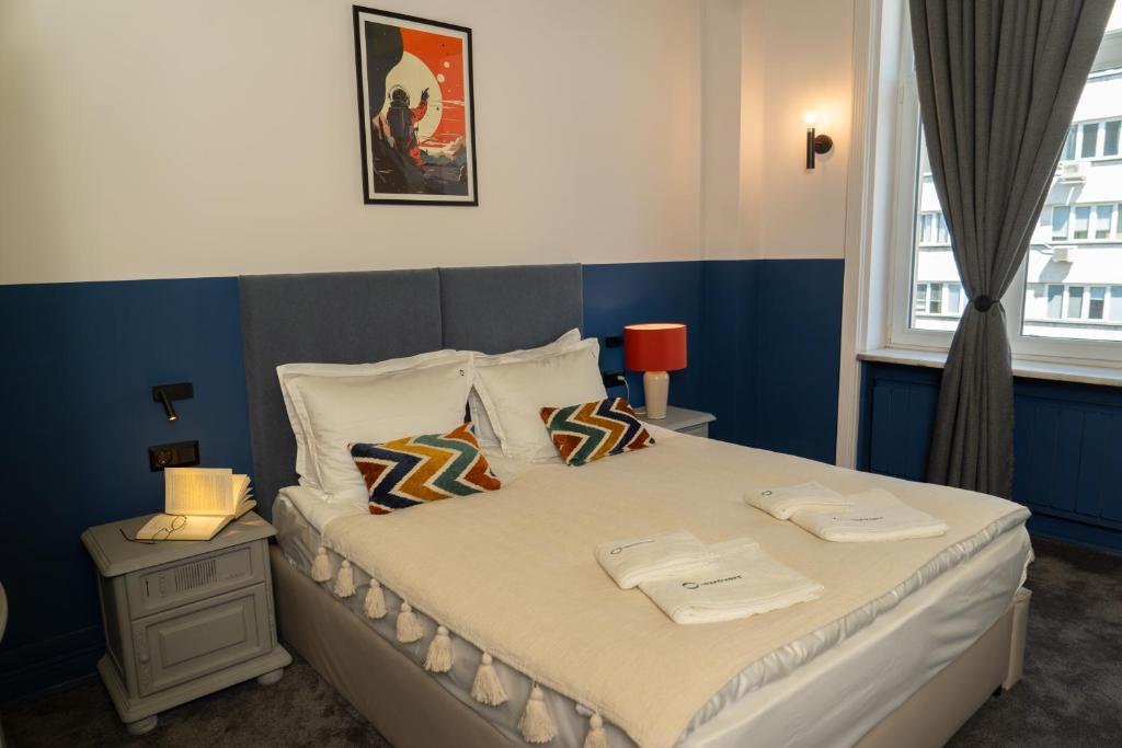 a bedroom with a large bed with a blue wall at Maria Luisa by INTROVERT HOTELS in Sofia