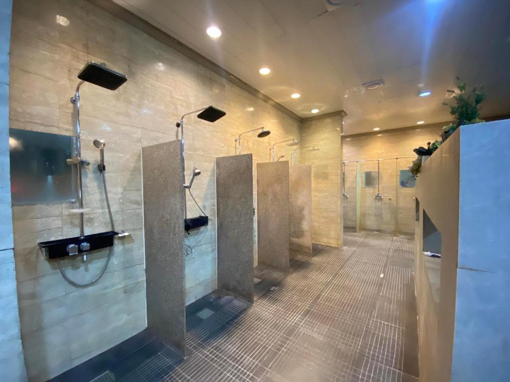 uma casa de banho com uma fila de urinóis e bancas em On Hotel Friendship em Angeles