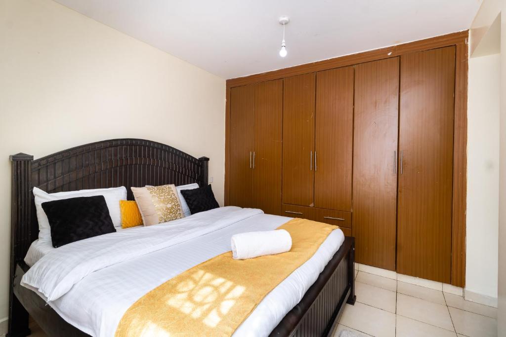 Athi River的住宿－Greatwall，一间卧室配有一张带木制橱柜的大床