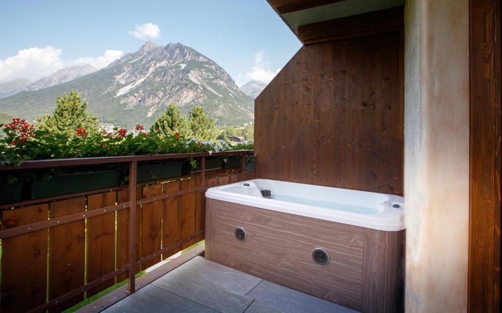 a bath tub on a balcony with a mountain at Agriturismo San Gallo in Bormio