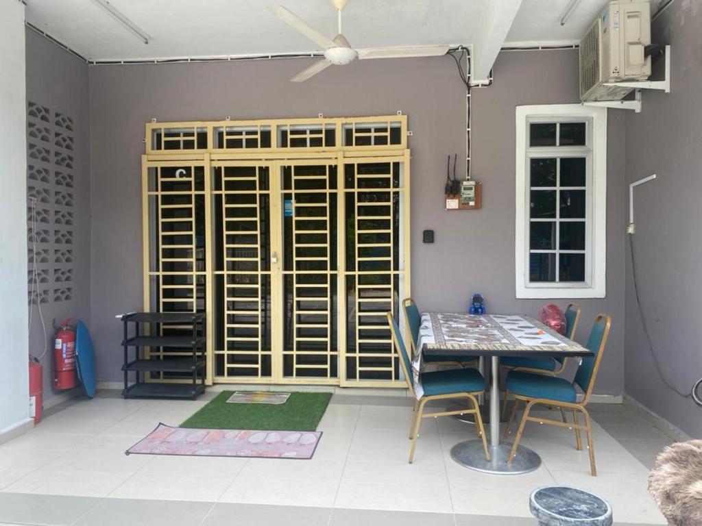 a dining room with a table and chairs and a window at Homestay Zalida C Musleem in Kampong Alor Gajah