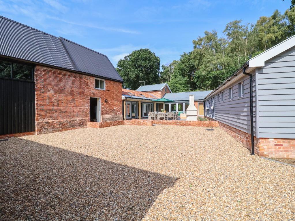 a brick house with a garage and a driveway at Church Farm Barn in Saxmundham
