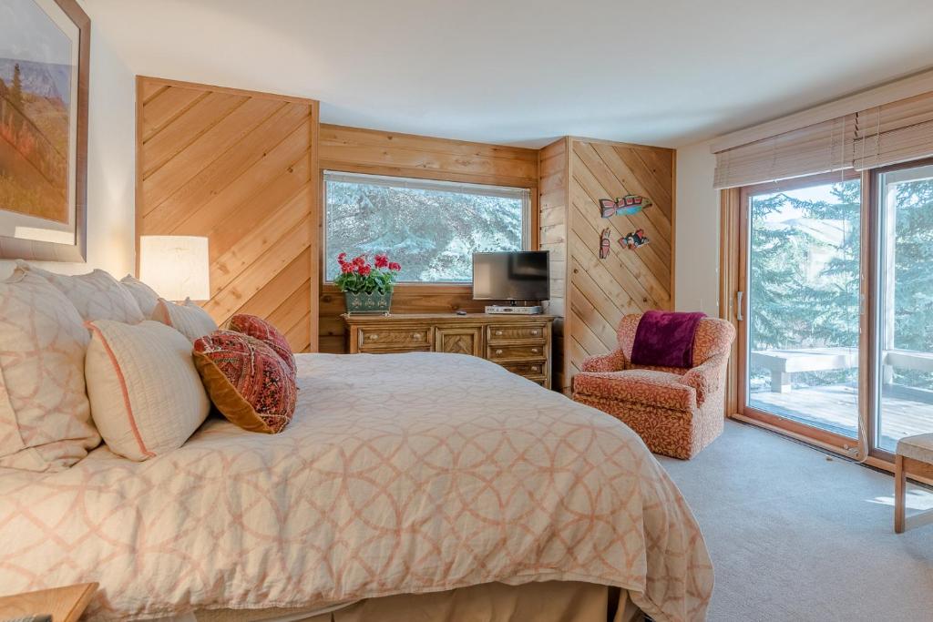 Sunburst Condo 2789 - Room for Up To 11 Guests and Elkhorn Resort Amenities في Elkhorn Village: غرفة نوم بسرير وتلفزيون وكرسي