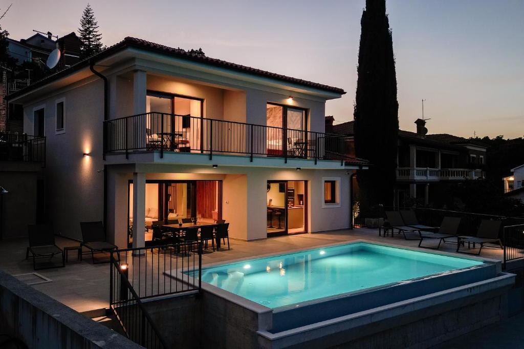 une maison avec une piscine en face d'une maison dans l'établissement Villa Norma, à Opatija