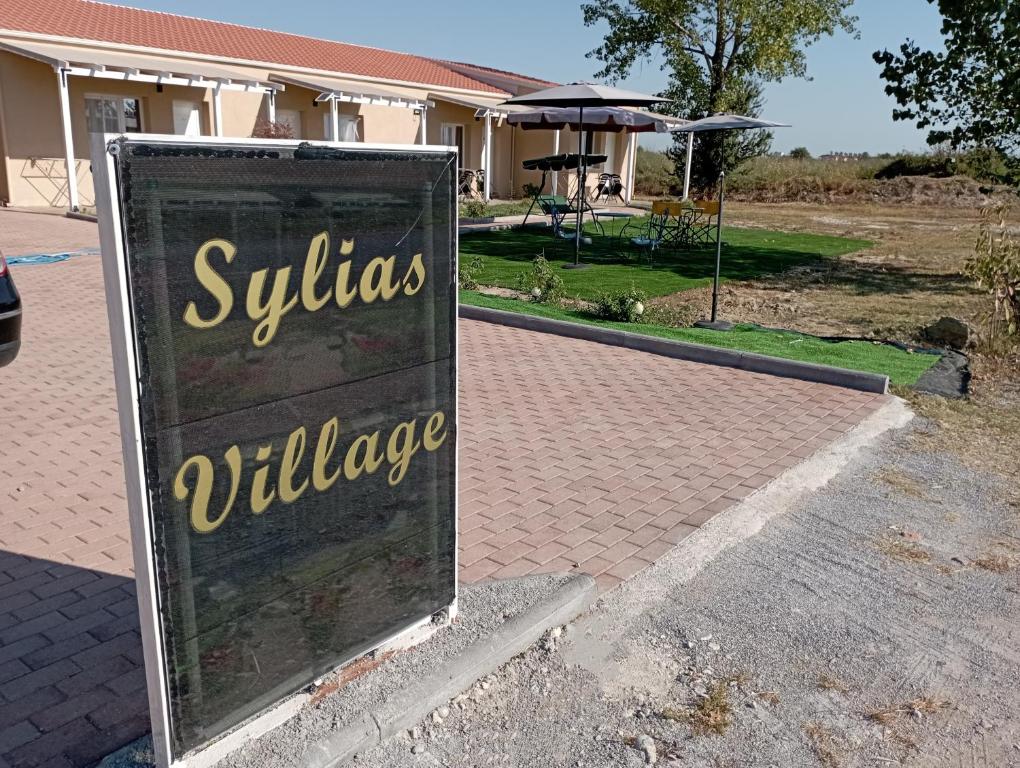 a sign that reads sylvias village in front of a house at sylias village in Skála Korinoú