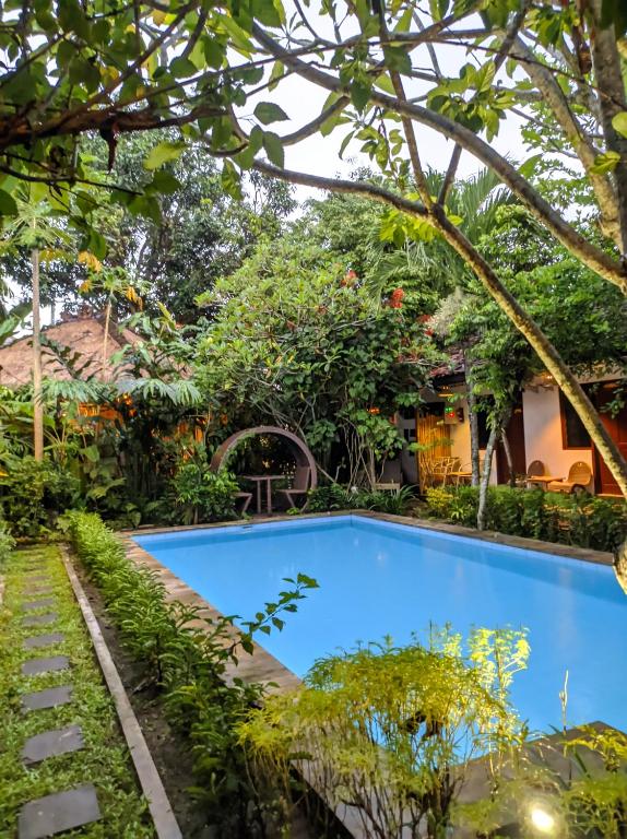 a swimming pool in the garden of a house at Pondok IJo Villa in Timuran