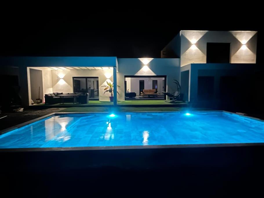 - une grande piscine bleue la nuit dans l'établissement Villa Catalya moderne piscine chauffée, à Carcassonne