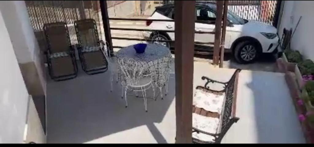 een tafel en stoelen op een balkon met een auto bij dg.apartaments in Alcamo