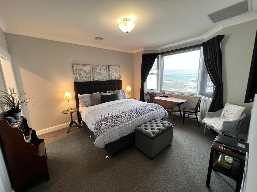 een slaapkamer met een bed, een stoel en een raam bij Number 10 -King bed with breakfast in Stanley