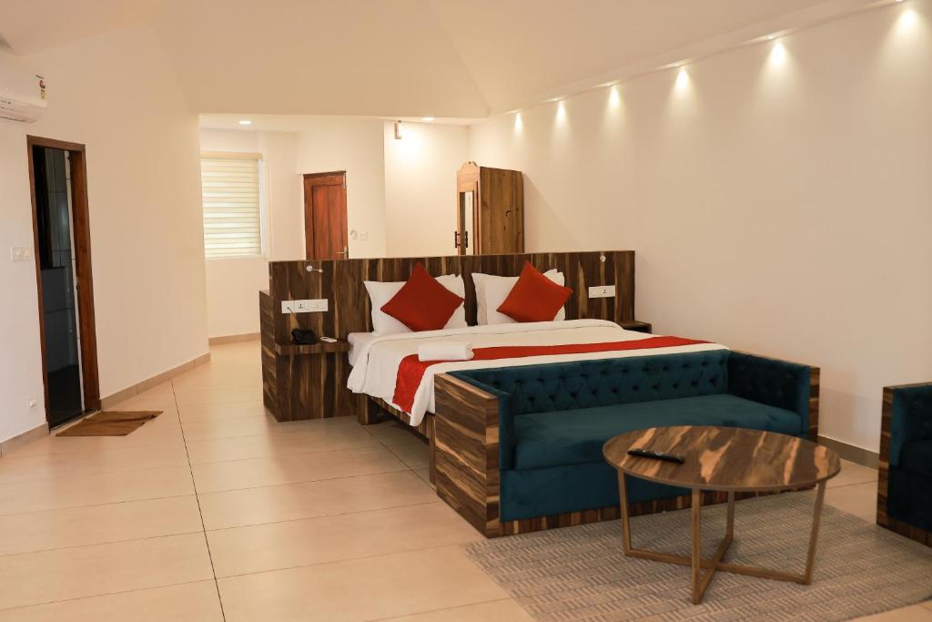 1 dormitorio con cama, sofá y mesa en Villa Sasha By Elixir Cliff, en Varkala