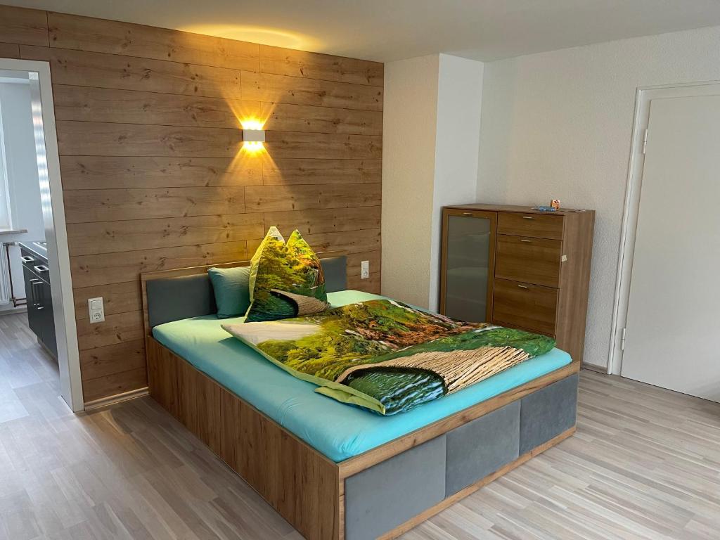 1 dormitorio con 1 cama con pared de madera en Ferienwohnung Adrian, en Sankt Andreasberg