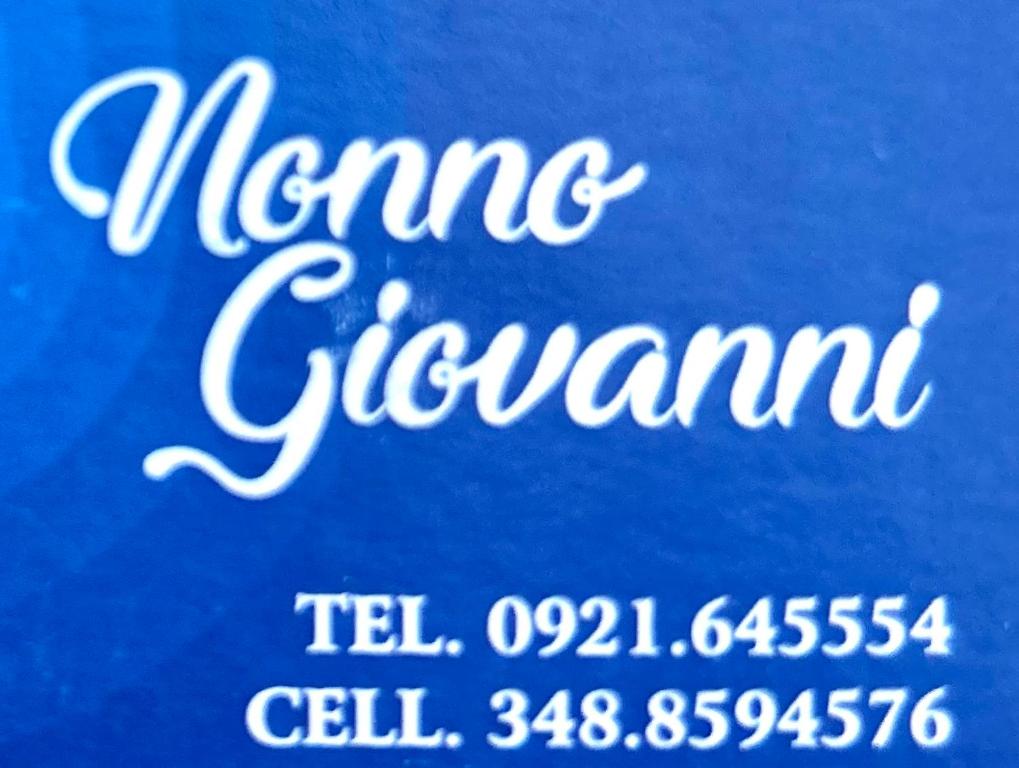 un cartel que dice el nombre de Agan en un fondo azul en Nonno Giovanni, en Gangi