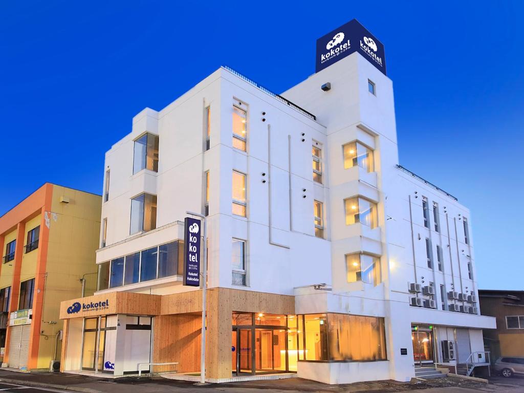 a white building with a clock on top of it at Kokotel Hakodate in Hakodate