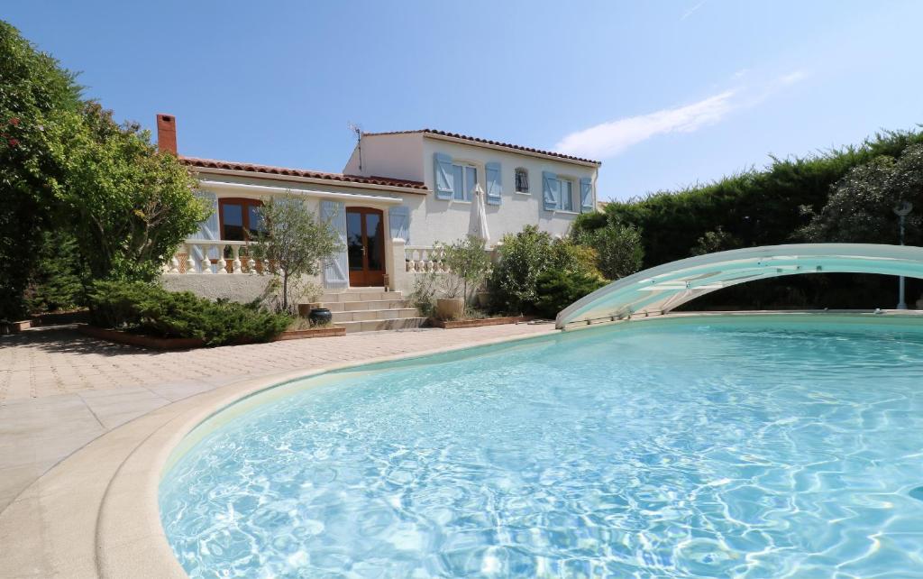 a large swimming pool in front of a house at Maison avec piscine in Saint-Georges-dʼOrques