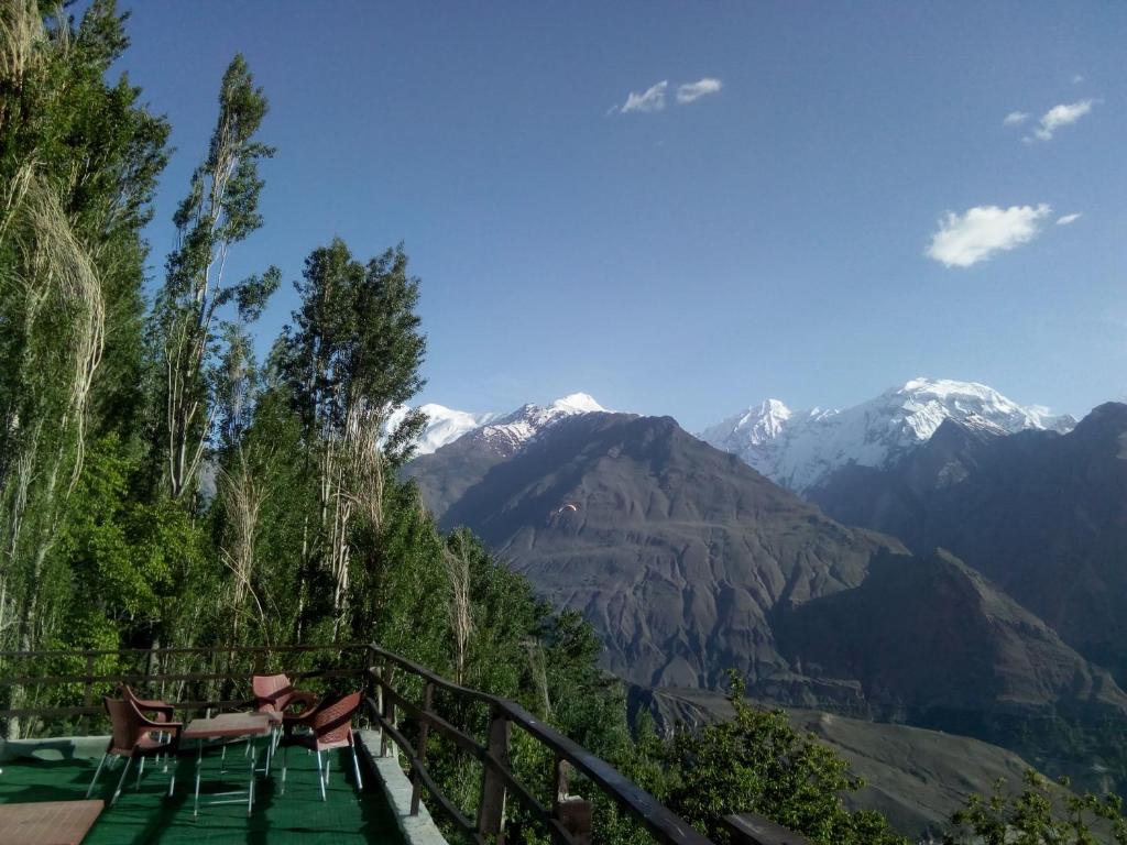 a balcony with chairs and a view of mountains at Venus Mountain Resort, Hunza in Hunza Valley