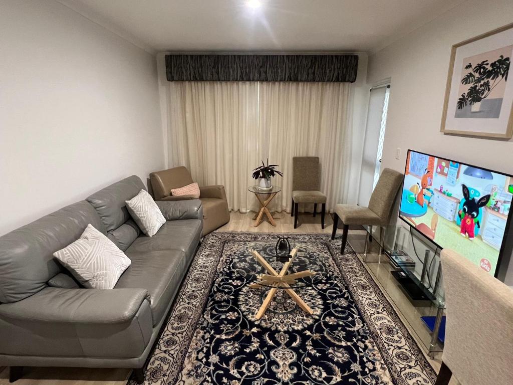 salon z kanapą i telewizorem z płaskim ekranem w obiekcie ADELAIDE CBD APARTMENT - 3BR, 2BATH & CARPARK w mieście Adelaide