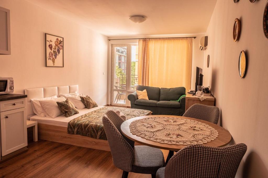 a bedroom with a bed and a table with chairs at bellissimo студио близо до плажа in Ravda
