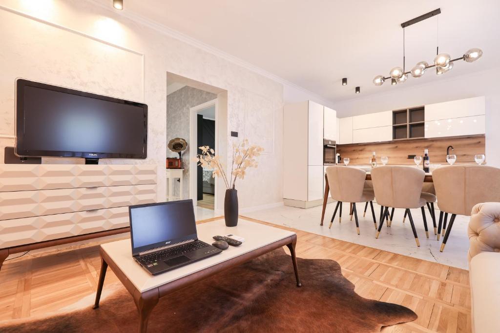 a living room with a laptop on a coffee table at Oscar & Leo Apartments in Zadar