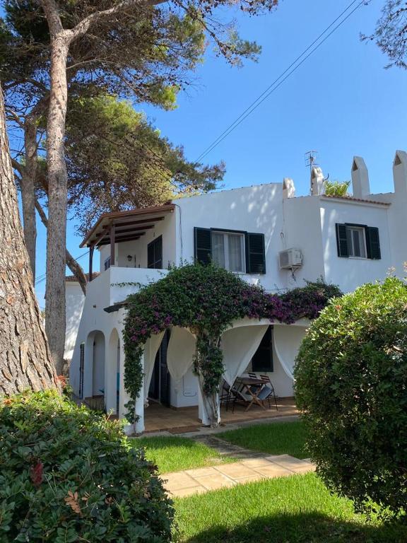 a white house with an archway in front of it at Bellver 1, Ciutadella-Cala Blanca in Cala Blanca