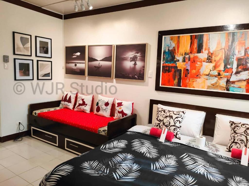 a bedroom with two beds and a painting on the wall at Centro Deluxe 3- Free Parking & WI-FI in Alabang in Manila