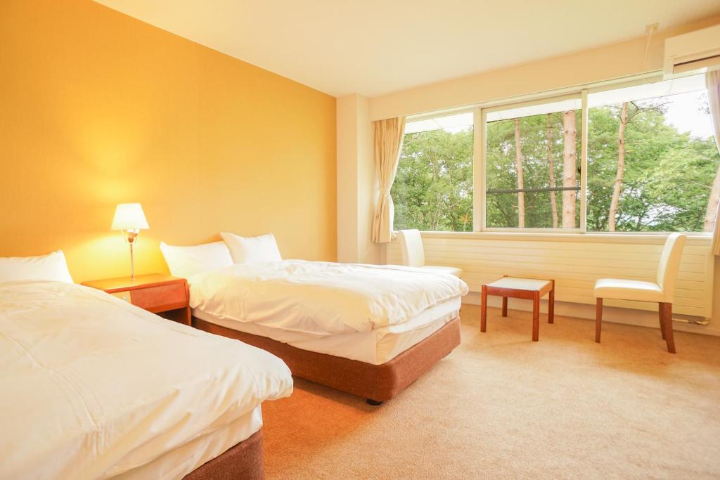 Postel nebo postele na pokoji v ubytování 北軽井沢　Golden Forest Hotel