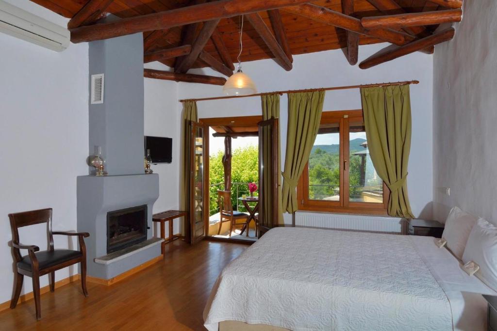 a bedroom with a bed and a fireplace at Alkifron Hotel in Kala Nera