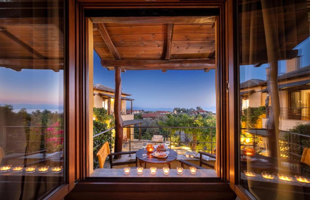 a room with a large window looking out onto a balcony at Alkifron Hotel in Kala Nera