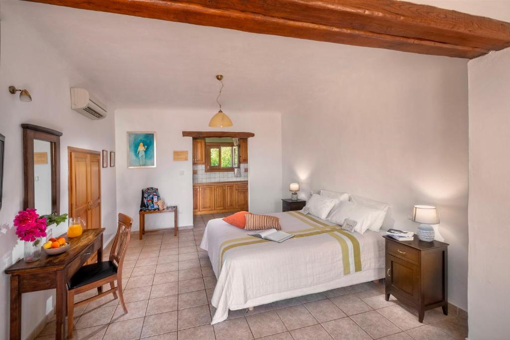 a bedroom with a bed and a table and a desk at Alkifron Hotel in Kala Nera