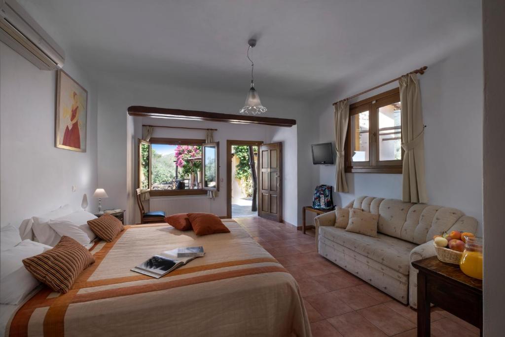 a living room with a large bed and a couch at Alkifron Hotel in Kala Nera