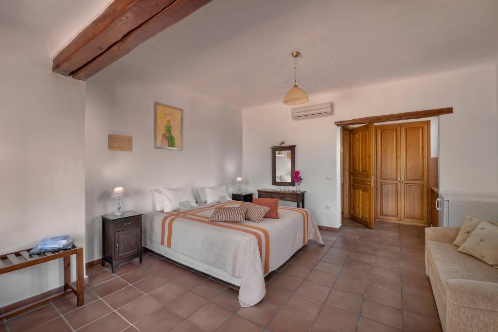 a bedroom with a bed and a couch at Alkifron Hotel in Kala Nera