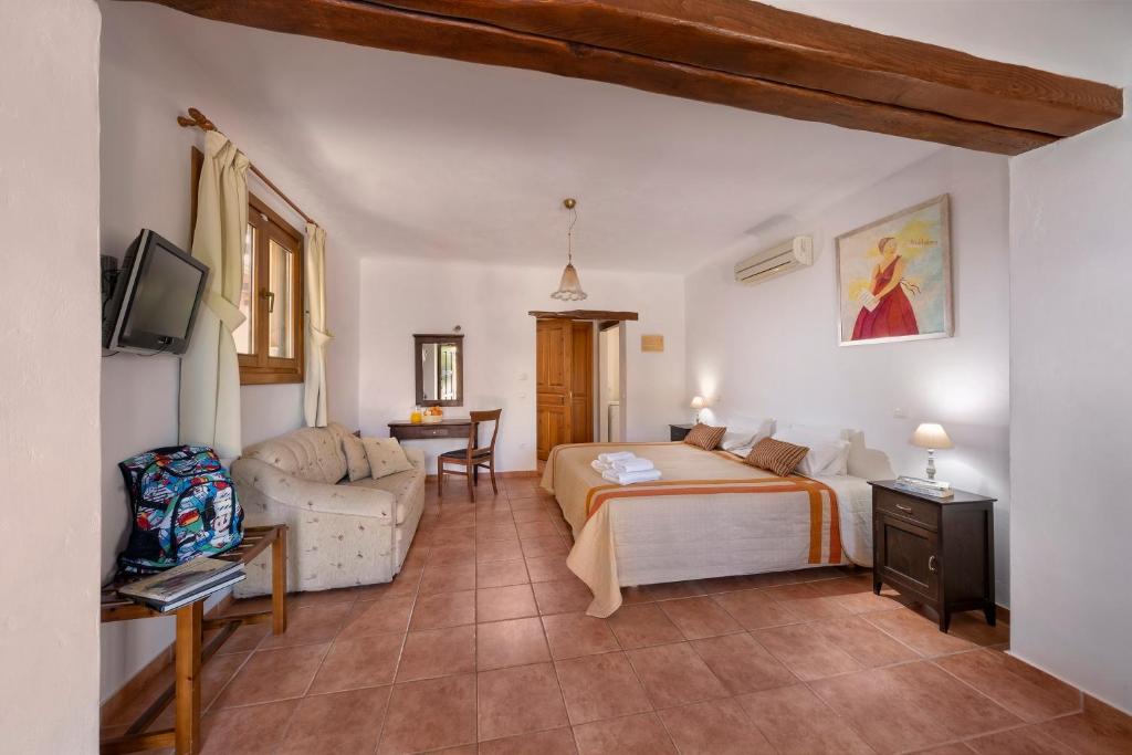 a bedroom with a bed and a couch in a room at Alkifron Hotel in Kala Nera