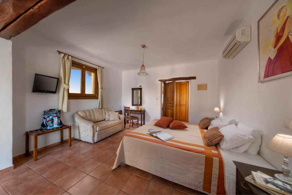a bedroom with a bed and a living room at Alkifron Hotel in Kala Nera