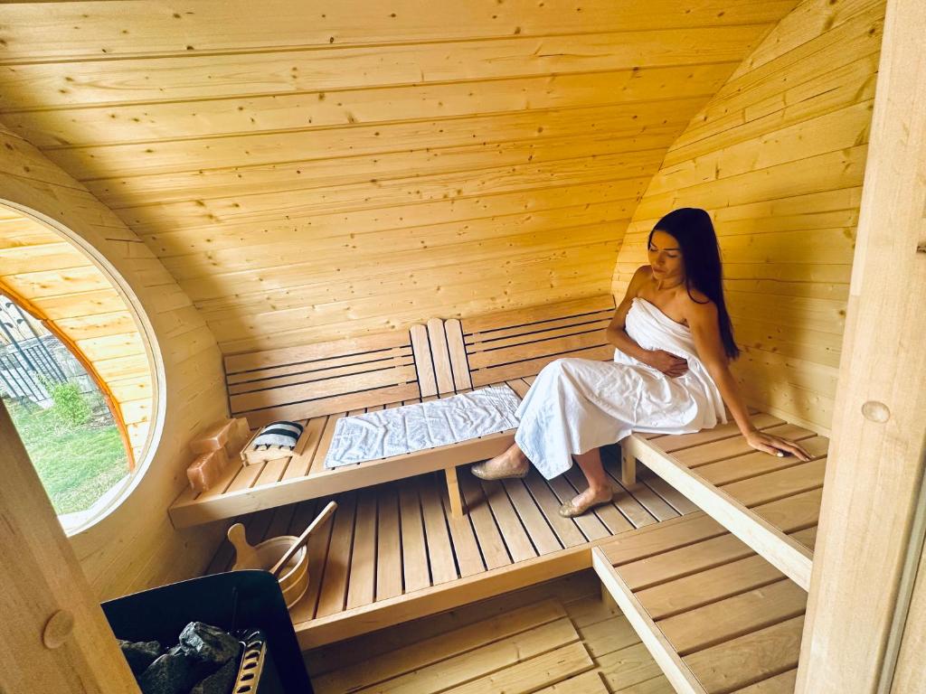 una mujer sentada en el interior de una sauna en Penzion Arendel en Líšnice
