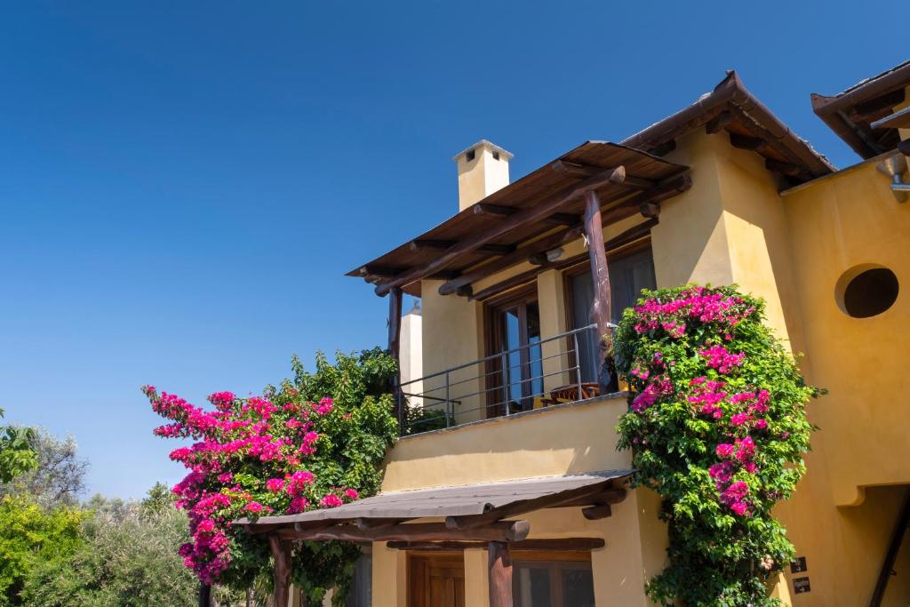 a house with flowers on the balconies at Alkifron Hotel in Kala Nera